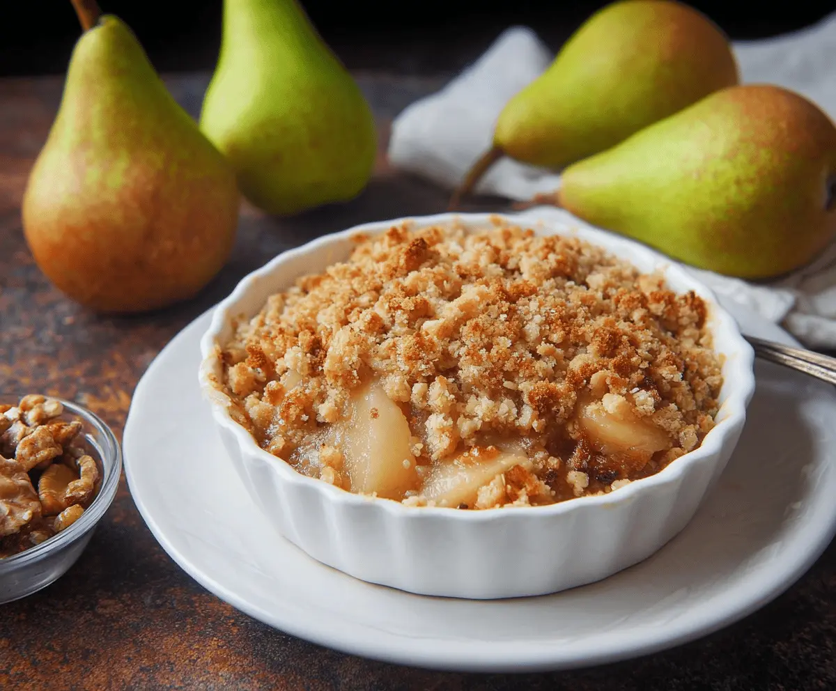 Delicious homemade pear crumble dessert with golden-brown topping and fresh pear filling, perfect for a cozy treat