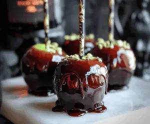 Delicious Poison Apple Caramel Apples coated with vibrant green candy, topped with colorful sprinkles and drizzled with dark chocolate, perfect for Halloween treats