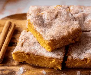 Delicious Pumpkin Snickerdoodle Bars with cinnamon sugar topping on a baking tray, perfect for fall desserts and sweet treats