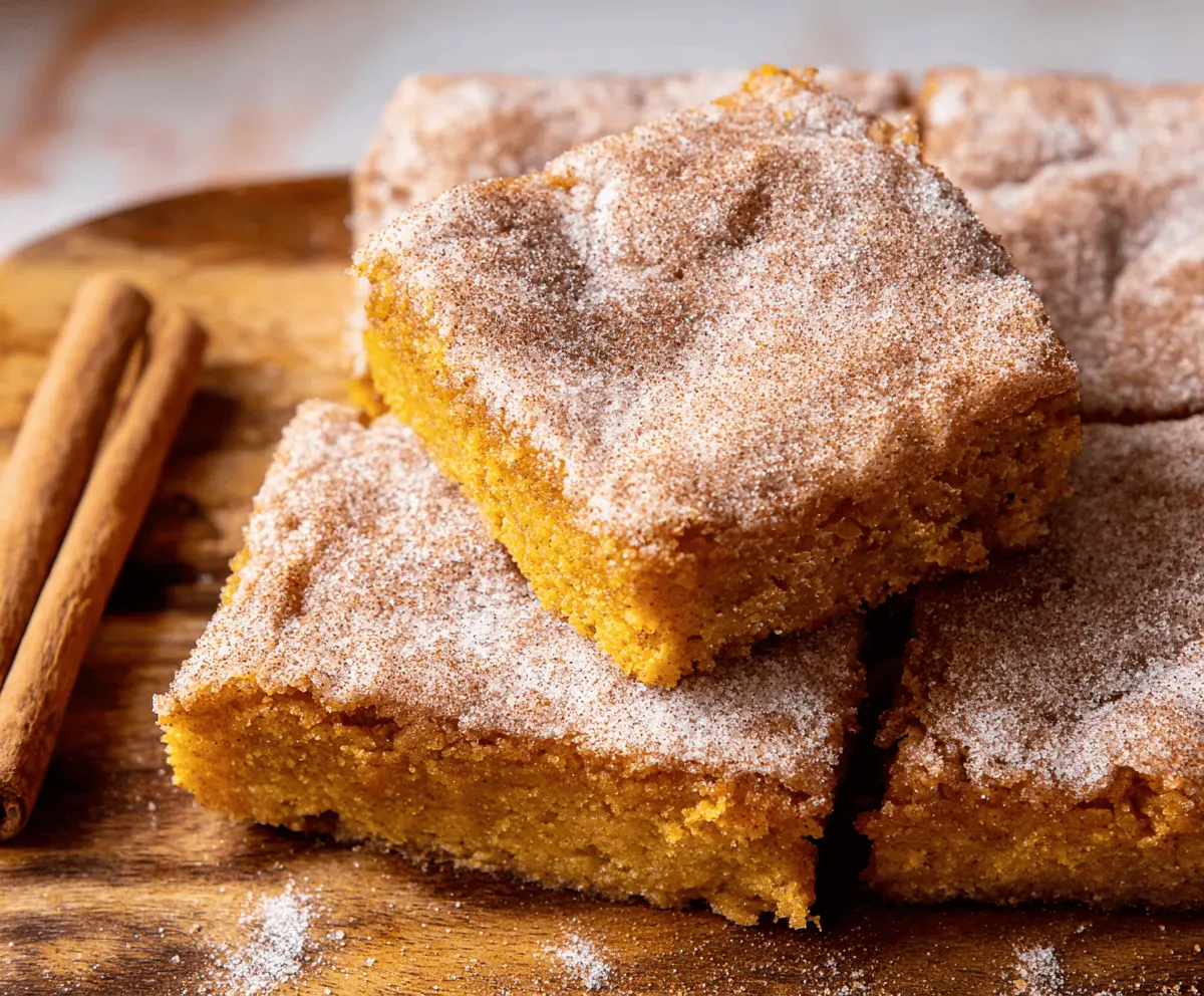 Delicious Pumpkin Snickerdoodle Bars with cinnamon sugar topping on a baking tray, perfect for fall desserts and sweet treats