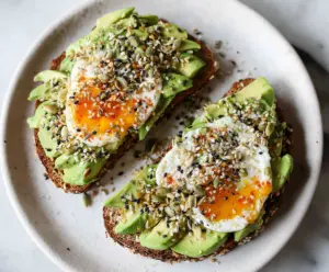 Close-up of a delicious everything bagel avocado toast topped with fresh avocado slices and seasoning.