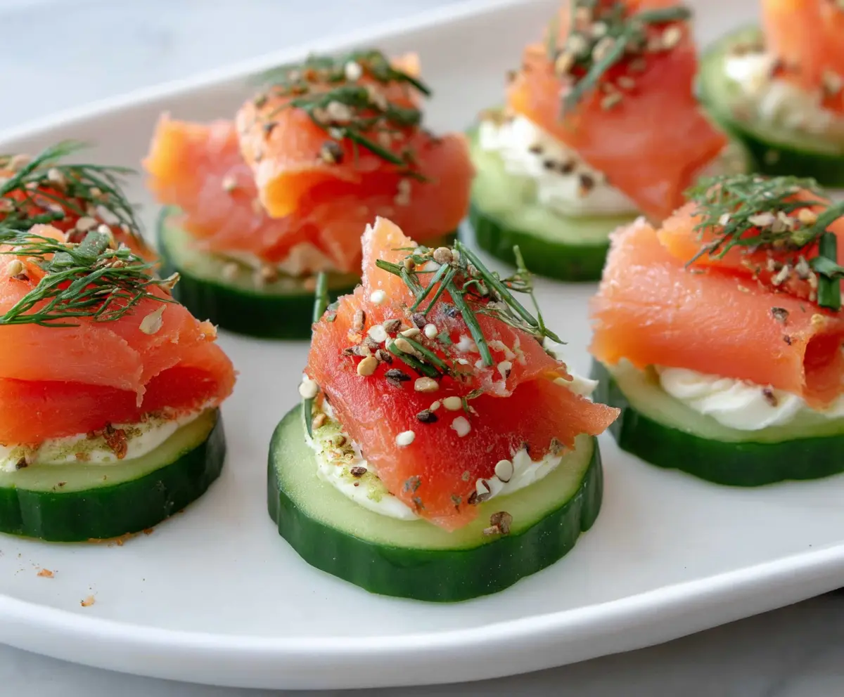 Delicious smoked salmon cucumber bites garnished with fresh herbs for an elegant appetizer.
