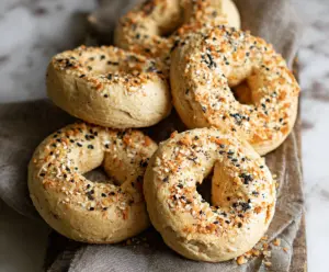 Delicious gluten-free Greek yogurt bagels on a plate, showing a golden crust and chewy interior.