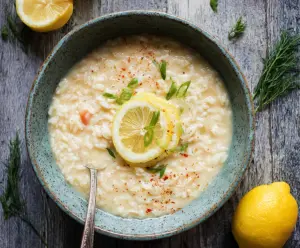 Delicious Greek Lemon Rice Soup in a bowl, garnished with fresh herbs, showcasing a comforting Mediterranean dish.