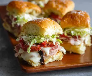 Delicious Italian Grinder Sliders featuring layers of ham, salami, and melted cheese on toasted buns.