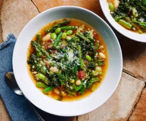 Fresh Spring Minestrone Soup with colorful vegetables and herbs in a bowl.