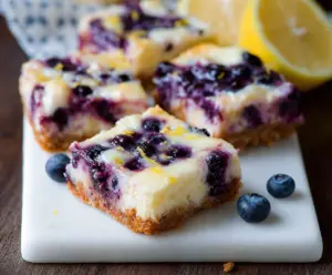 Delicious Blueberry Lemon Cheesecake Bars with a crisp crust and fresh fruit topping