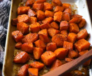 Delicious cinnamon roasted sweet potatoes on a plate, seasoned with warm spices.
