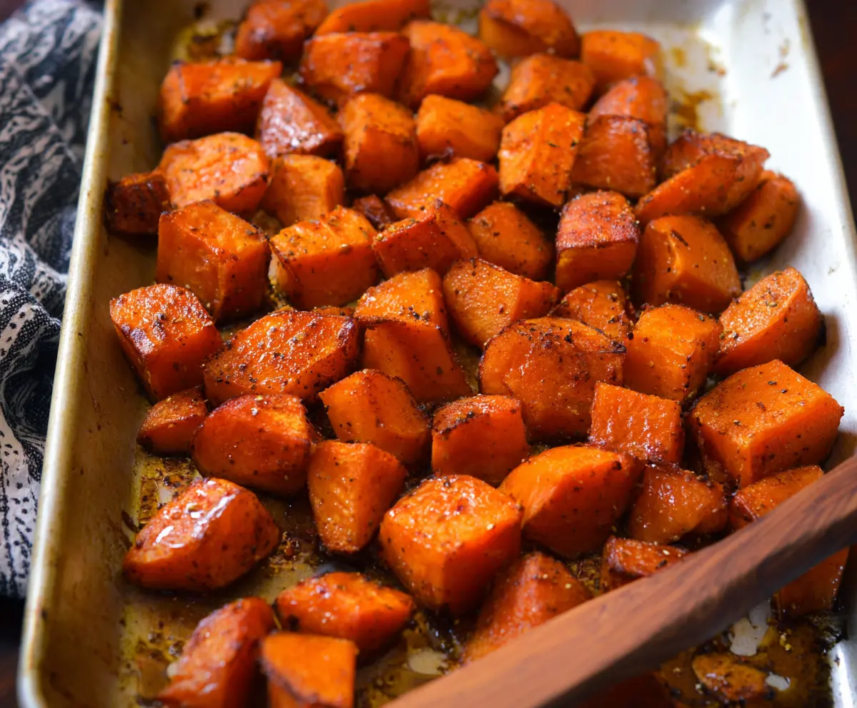 Delicious cinnamon roasted sweet potatoes on a plate, seasoned with warm spices.