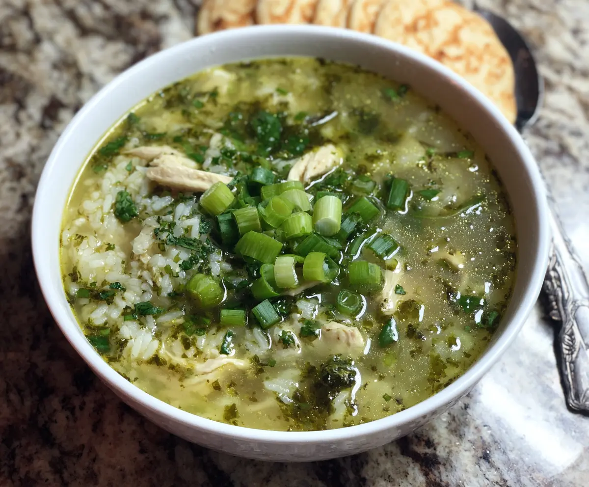 Delicious green garlic and ginger chicken and rice soup served in a bowl with fresh herbs.