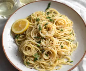 Delicious Lemon Butter Garlic Pasta served in a bowl with fresh herbs and lemon wedges.