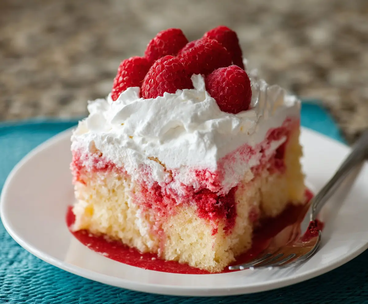 Delicious Raspberry Poke Cake with fresh raspberries and creamy filling for a sweet dessert